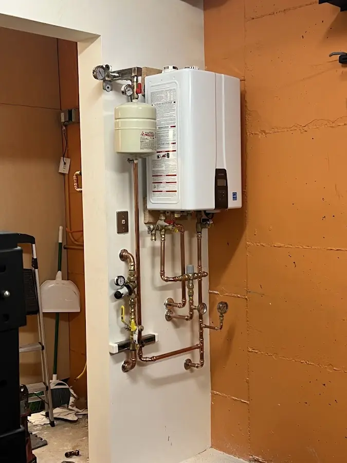 Plumbing technician inspecting water heater connections in Pilot Point